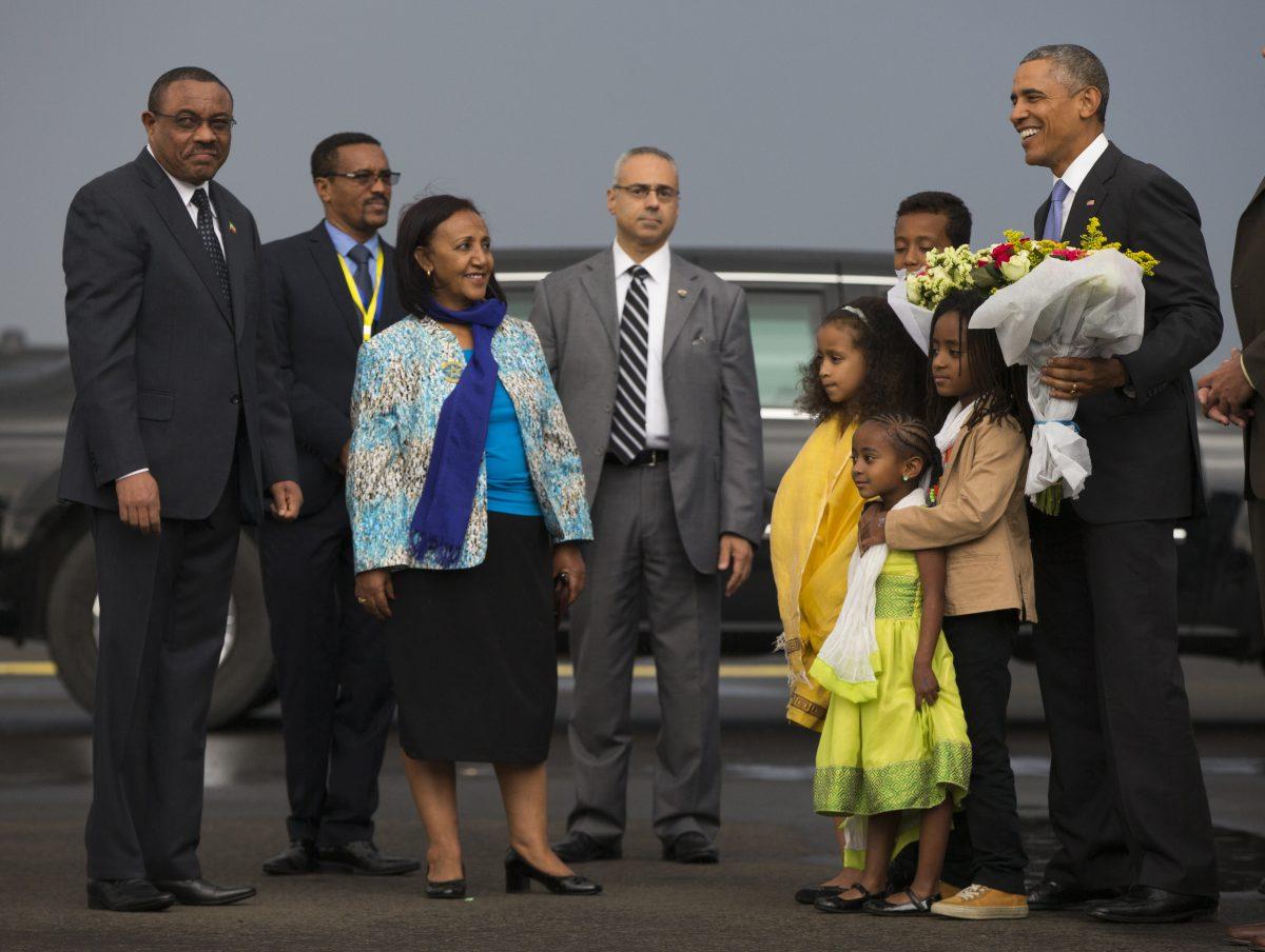 Ethiopian Prime Minister Hailemariam Desalegn (L) looks on as President Barack Obama is given a bouquet as he arrives at Addis Ababa Bole International Airport in Addis Ababa on July 26, 2015. (Evan Vucci/AP Photo)