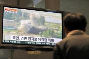 A TV screen in Seoul, South Korea, showing footage of the public demolition of the cooling tower at North Korea's Yongbyon nuclear complex on June 27, 2008. (Jung Yeon-Je/AFP/Getty Images)