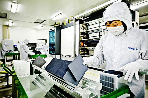 A masked worker sorts silicon wafers at the manufacturing center of solar cell maker Trina Solar in Changzhou, China, in November 2009. (Philippe Lopez/AFP via Getty Images)
