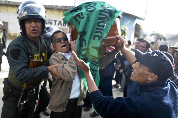 Peruvian police block the way for people carrying the coffins of three demonstrators who died during the protests against the Conga mining project in Celendín, Cajamarca, Peru, on July 6, 2012. The death toll from clashes between security forces and demonstrators fighting a planned $4.8 billion gold mine by U.S.-based Newmont in northern Peru climbed to five. (Ernesto Benavides/AFP/GettyImages)