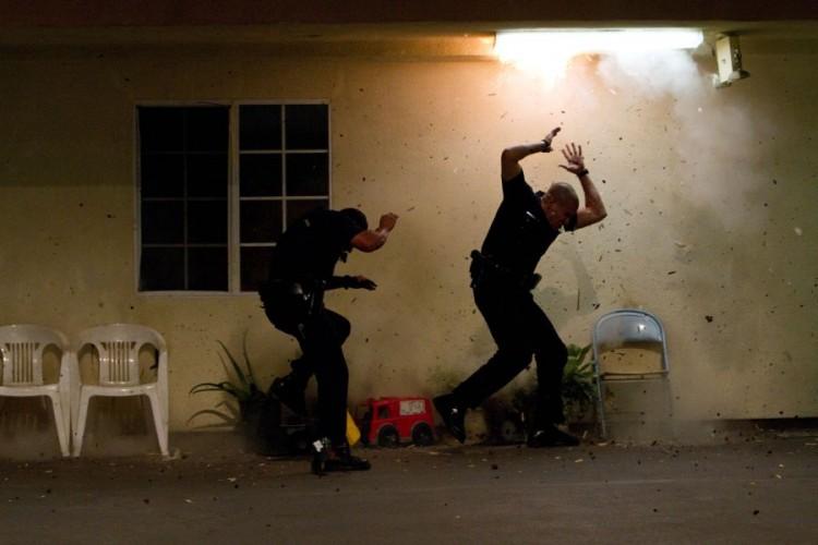 Michael Peña (L) and Jake Gyllenhaal play LAPD cops escaping gang gunfire in "End of Watch." (Scott Garfield/Open Road Films)