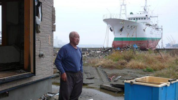 Genitsu Ito stands outside his tsunami-ravaged home in Higashimatsushima, Miyagi Prefecture, Japan, on Oct. 15. A short distance away, the tsunami deposited a 452-ton fishing boat. (Cindy Drukier/The Epoch Times)