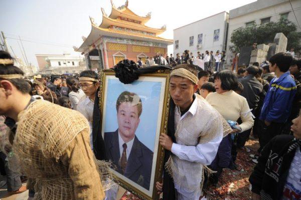 Relatives carry a picture of Xue Jinbo, the village leader who died in police custody, in Wukan, Guangdong Province, China, on Dec. 16, 2011.