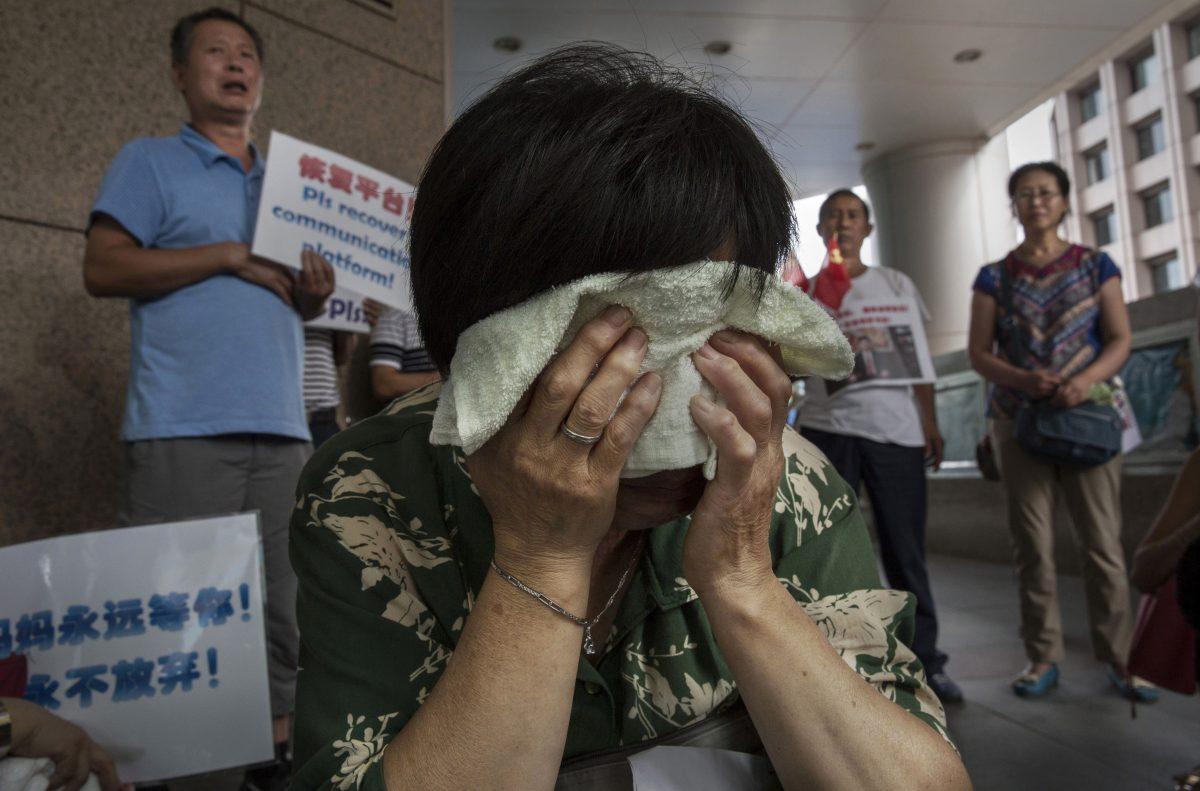 Bao Lanfang, a Chinese relative of missing passengers on Malaysia Airlines flight MH 370 cries as she waits for information outside the airline's office on Aug. 6, 2015 in Beijing, China. (Kevin Frayer/Getty Images)