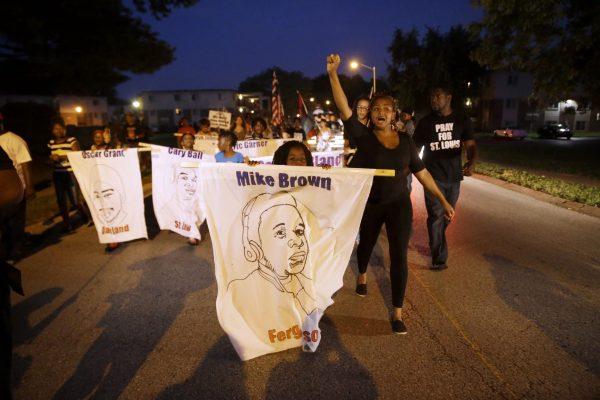 Protesters march down Canfield Drive near where Michael Brown was killed in Ferguson, Mo., on Aug. 7, 2015. Sunday will mark one year since Brown was fatally by Ferguson police officer Darren Wilson. (AP Photo/Jeff Roberson)