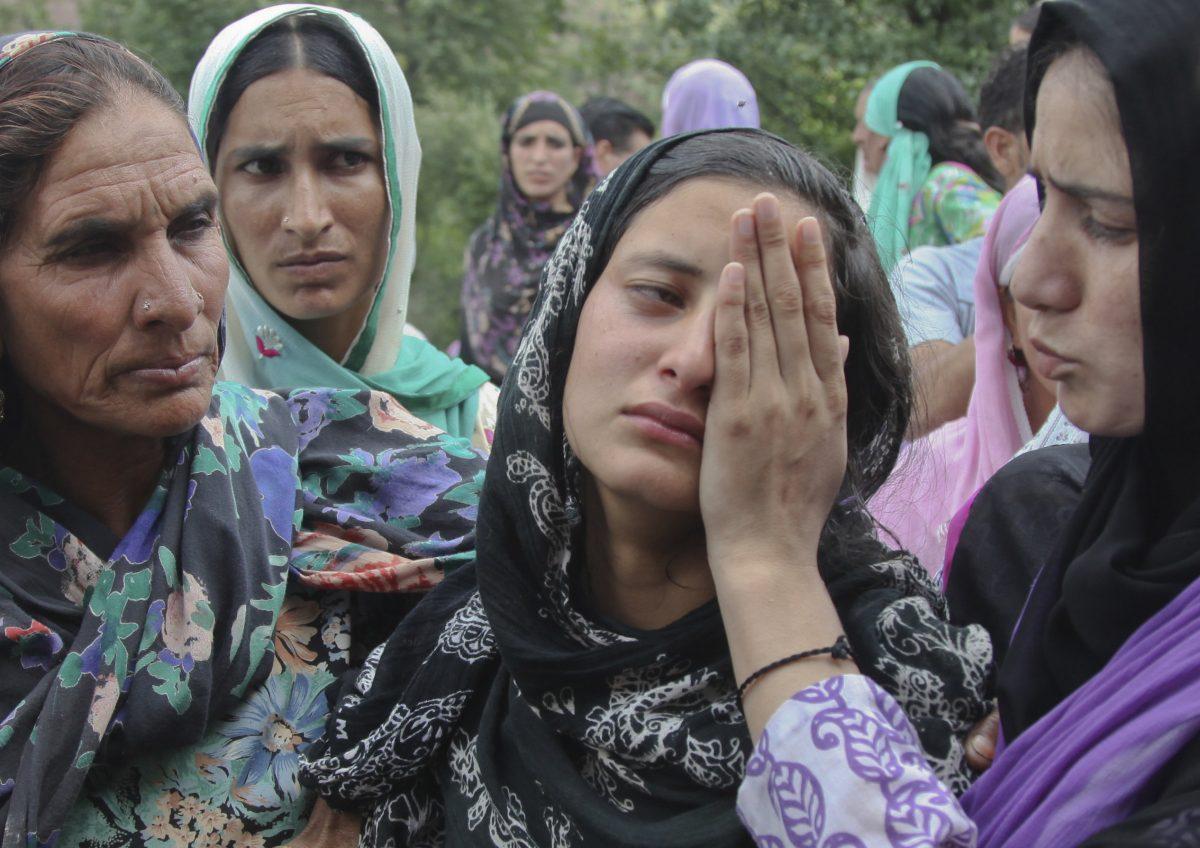 The daughter (C) of Indian civilian Sarpanch Karamat Hussain who was killed in Pakistani shelling, wails at Balakot sector in Poonch, Jammu and Kashmir, India, on Aug.16, 2015. Indian and Pakistani troops traded heavy gunfire and mortar rounds for a seventh day Sunday along the highly militarized line of control dividing the disputed Himalayan region of Kashmir between the two archrivals, officials said. (AP Photo/Channi Anand)