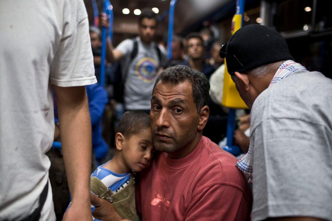 Merkel Demands EU Partners Share Burden of Migrant Influx