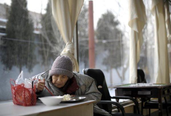 An elderly woman eating a meal in a nursing home. China's “one-child policy” and aging heighten the shortage of elder care. (Liu Jin/AFP/Getty Images)