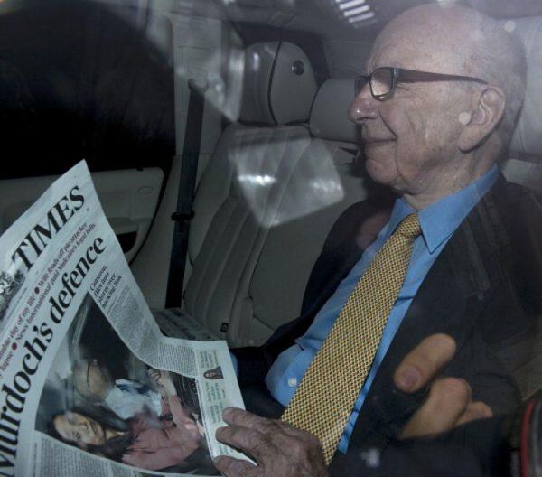 News Corp. Chief Rupert Murdoch reads a copy of one of his newspapers, The Times, as he leaves his London home on July 20, 2011. (Carl Court/AFP/Getty Images )