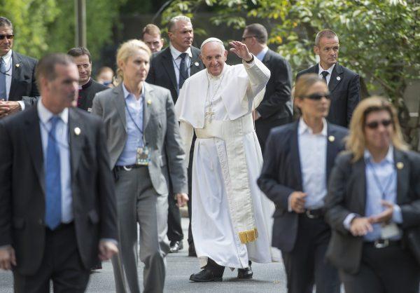 Pope Francis, surrounded by security, waves to well-wishers at the Apostolic Nunciature to the United States upon returning from his trip to Capitol Hill, on Sept. 24, 2015, in Washington. (Molly Riley/AFP/Getty Images)