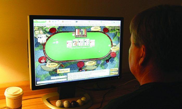 A man plays poker on his computer connected to an Internet gaming site from his home in this file photo. (Karen Bleier/AFP/Getty images)