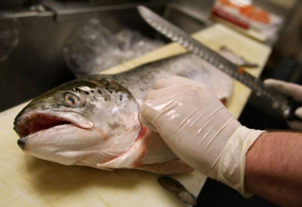 A worker uses a knife to fillet a salmon in a supermarket in Northern California. (Justin Sullivan/Getty Images)