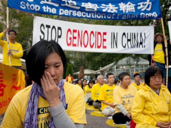 A Falun Gong practitioner wipes away tears while listening to a fellow practitioner recount her brutal treatment in a Chinese labor camp outside of the U.N. building in Manhattan on Sept. 20, 2011. (Amal Chen/The Epoch Times)