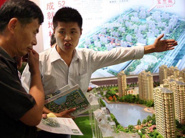 A salesman introduces property to a potential buyer at the Shanghai Real Estate Trade Fair And Exhibition on July 11, 2008 in Shanghai, China. (China Photos/Getty Images)