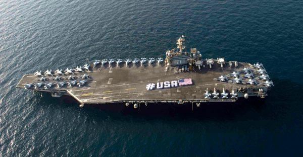 Sailors spell out #USA with the American flag on the flight deck of the aircraft carrier USS Theodore Roosevelt in a file photo. (Mass Communication Specialist 3rd Class/U.S. Navy, CC BY)