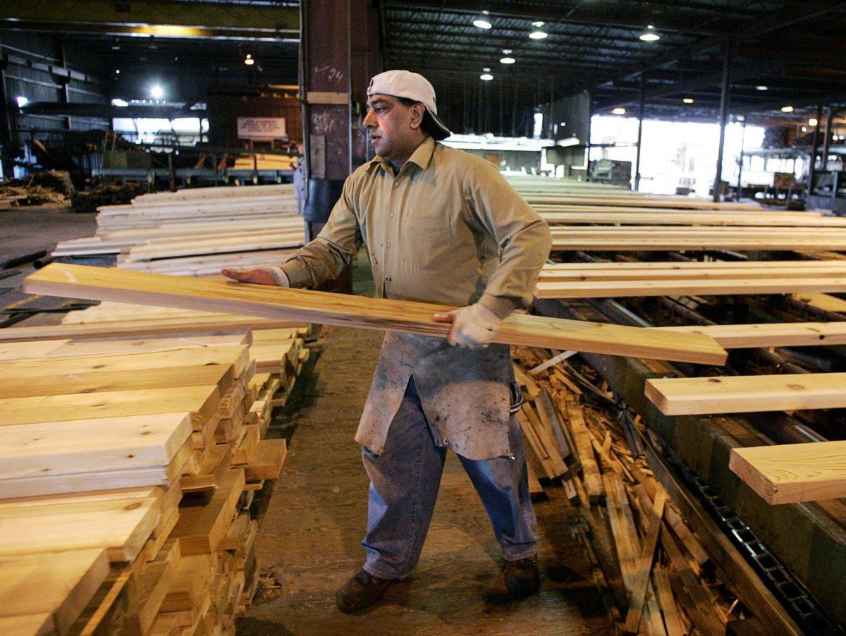 A worker sorts lumber at the Pan-Abode Mill in Richmond, Canada on April 27, 2006. (CP PHOTO/Chuck Stoody)