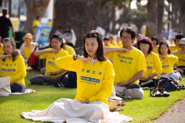 Falun Gong practitioners do the sitting meditation exercise at Santa Monica Pier, Los Angeles on Oct. 17, 2015. (Larry Dye/Epoch Times)