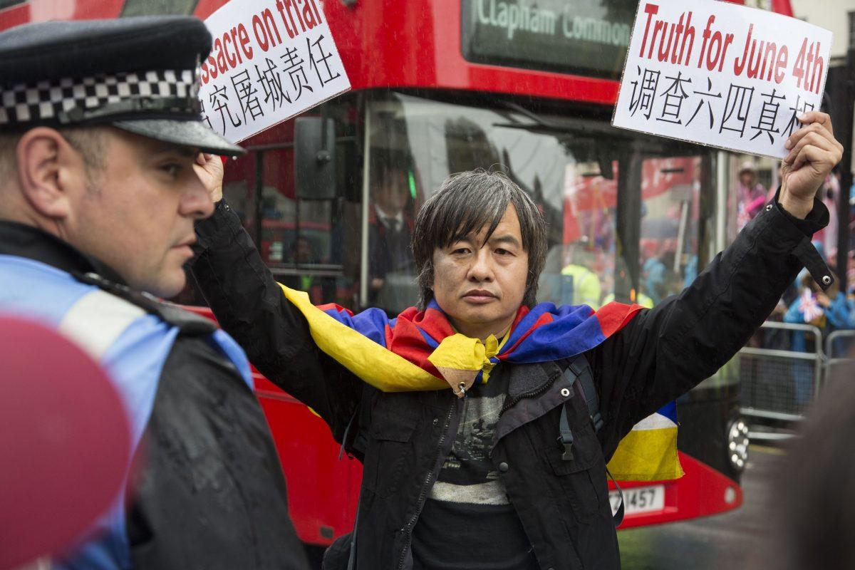 Tiananmen survivor and democracy activist Shao Jiang holding placards before being arrested during Chinese leader Xi Jinping’s state visit in London on Oct. 21, 2015 (Si Gross/Epoch Times)