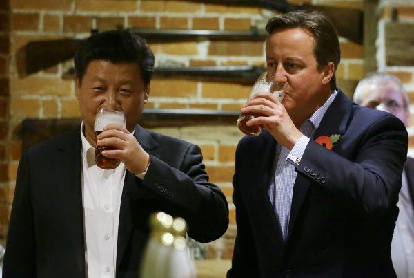 China's leader Xi Jinping and Britain's Prime Minister David Cameron drink a pint of beer during a state visit to the United Kingdom. Deals estimated to be worth £30 billion were agreed during the visit. (Kirsty Wigglesworth/WPA Pool/Getty Images)