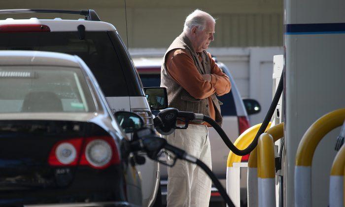 A customer pumps gasoline into his car at an Arco gas station in Mill Valley, Calif., on March 3, 2015. (Photo by Justin Sullivan/Getty Images)
