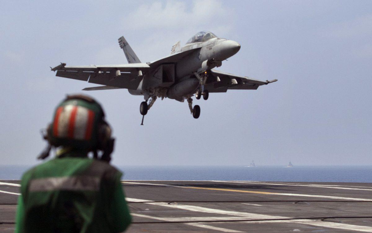 A U.S. Navy fighter jet approaches to land on the aircraft carrier USS Theodore Roosevelt (CVN 71), a missile cruiser and a nuclear-powered submarine during Exercise Malabar 2015, some 152 miles off eastern coast of Chennai, India, on Oct. 17, 2015. (Arun Sankar K./AP Photo)
