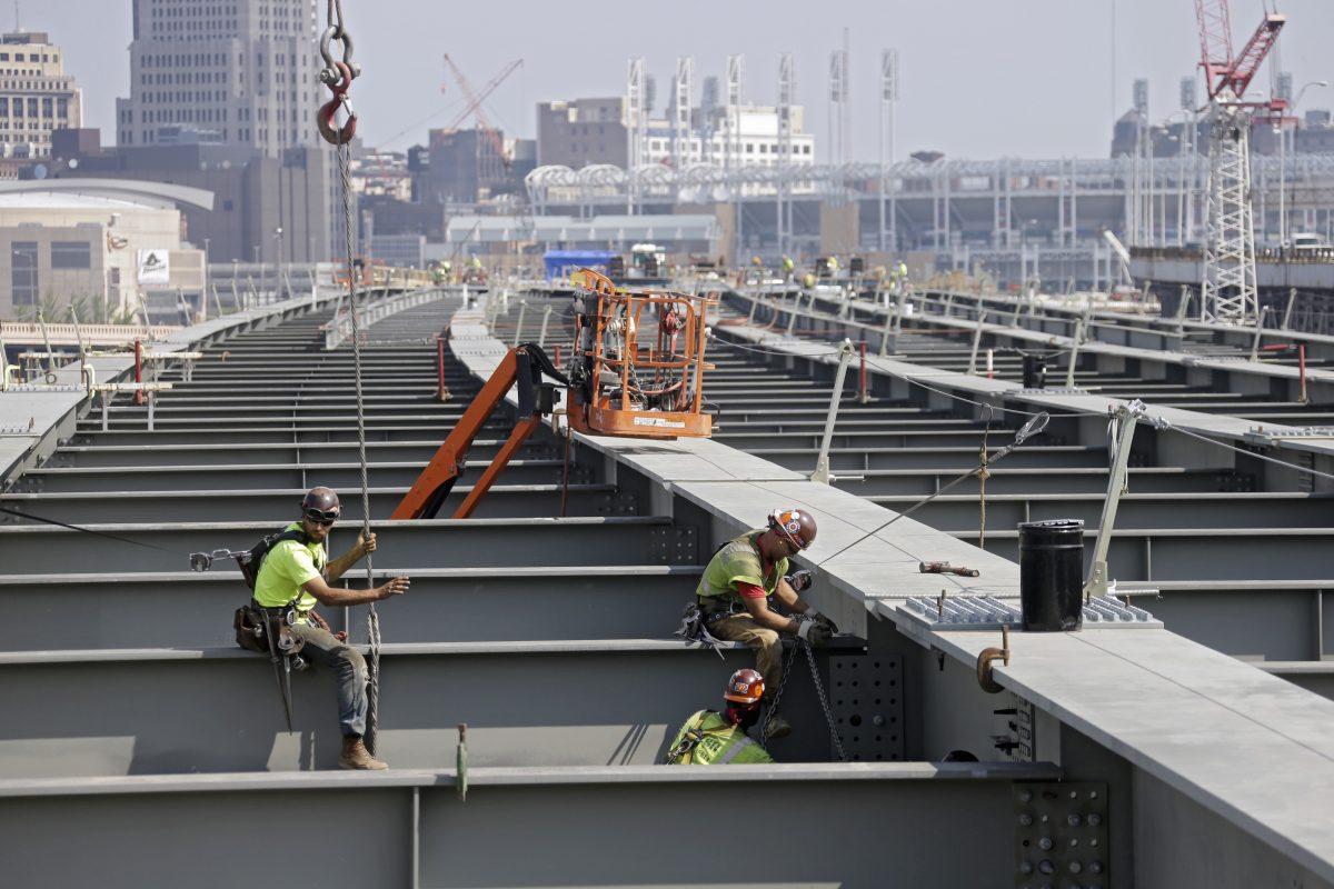 Ironworkers secure a cross member on a highway bridge under construction in Cleveland in 2013. (AP Photo/Mark Duncan)