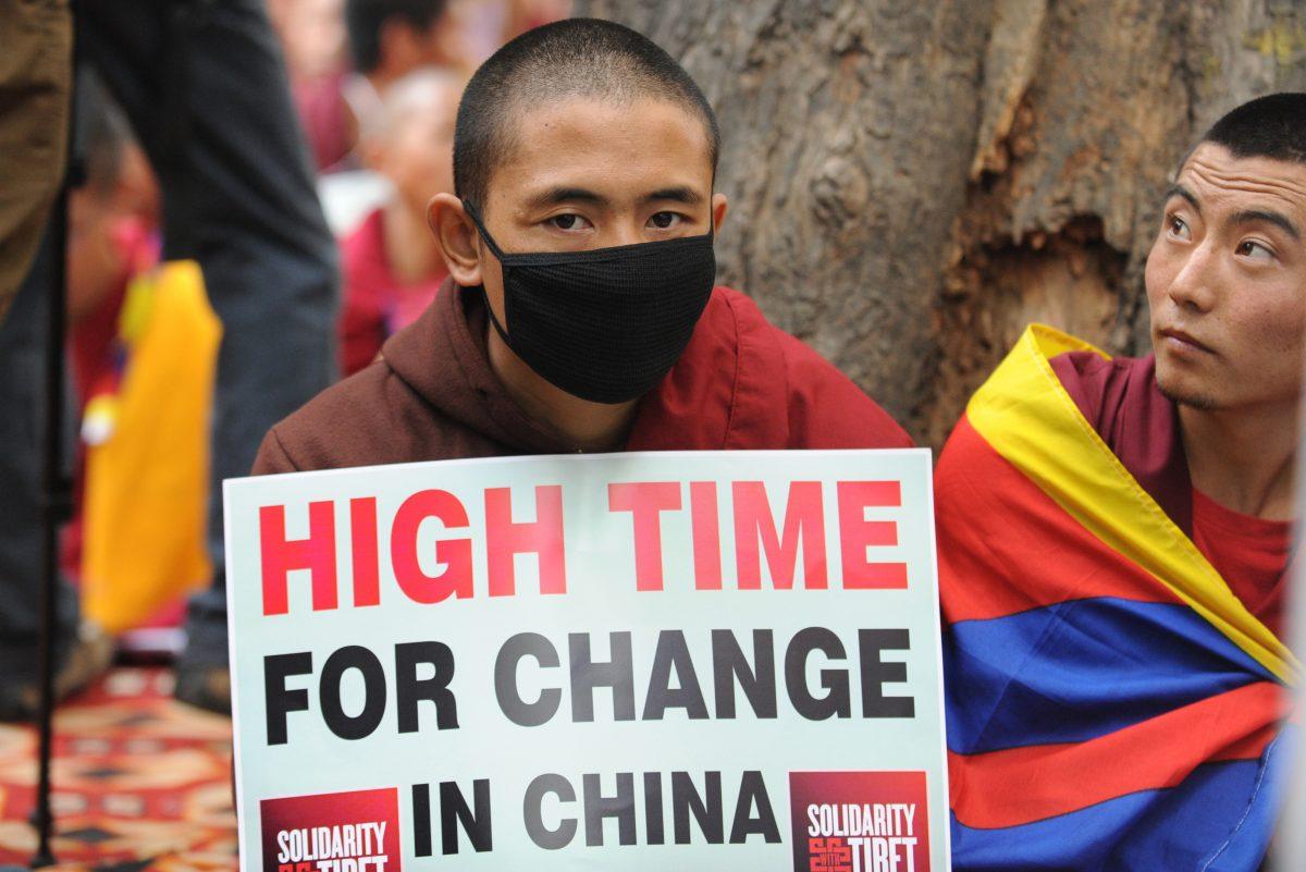 Tibetan monks hold placards during a protest rally in New Delhi on Jan. 31, 2013. The Chinese regime has deployed a new surveillance system, which will make it more difficult for Tibetans to escape to Nepal. (Raveendran/AFP/Getty Images)