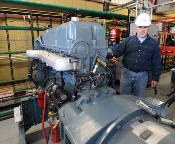 Ingenco Director of Construction Tom Hecmanczuk shows one of the engines that will run on methane gas from the Bristol Virginia Landfill to produce electricity to sell to the TVA, Nov. 19, 2015. (David Crigger/Bristol Herald-Courier via AP)
