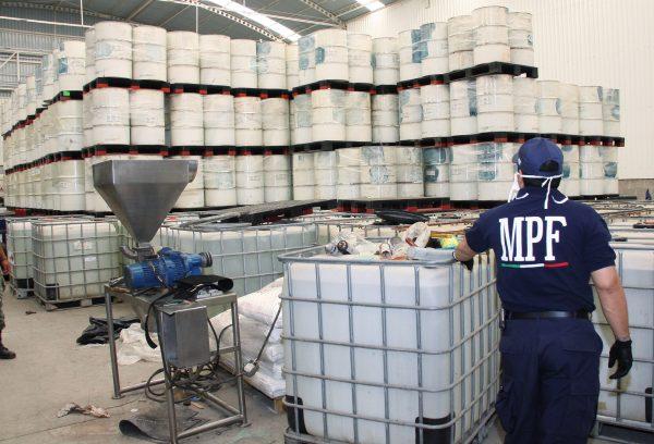 Police from the Federal Public Ministry examine drums of precursor chemicals for methamphetamine that were seized in Queretaro, Mexico, on June 20, 2011. (AP Photo/Attorney General's office)