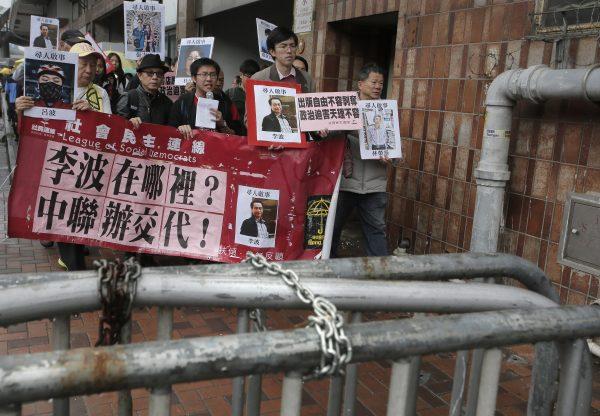 Protesters hold photos of missing booksellers during a protest outside the Liaison of the Central People's Government in Hong Kong, on Jan. 3, 2016. (Vincent Yu/AP Photo)