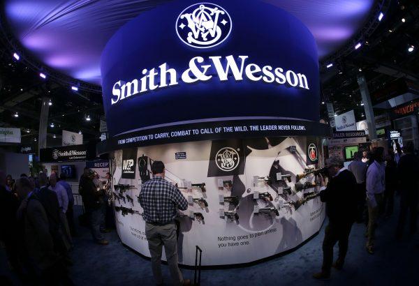 Trade show attendees examine handguns and rifles in the Smith & Wesson display boot at the Shooting Hunting and Outdoor Tradeshow, in Las Vegas, Nev., on Jan. 14, 2014. (AP Photo/Julie Jacobson, File)