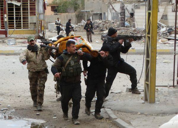 Iraqi security forces and allied Sunni tribal fighters evacuate an injured woman after she was shot by ISIS fighters in Ramadi, 70 miles west of Baghdad, on Jan. 4, 2016. (AP Photo)