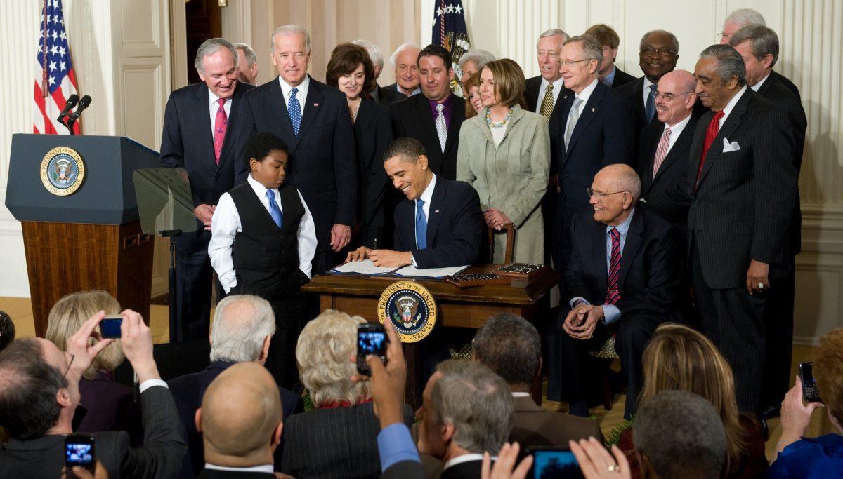 President Barack Obama signs the health care insurance reform legislation during a ceremony in the East Room of the White House on March 23, 2010. (Saul Loeb/AFP/Getty Images)