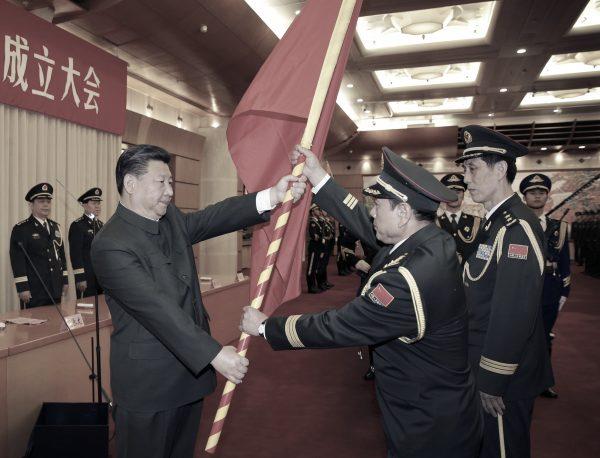 (L–R) Chinese Communist Party leader Xi Jinping gives a military flag to Wei Fenghe, commander of the Rocket Force of the Chinese People's Liberation Army (PLA), and Wang Jiasheng, political commissar of the Rocket Force in Beijing, on Dec. 31, 2015. (Li Gang/Xinhua via AP)
