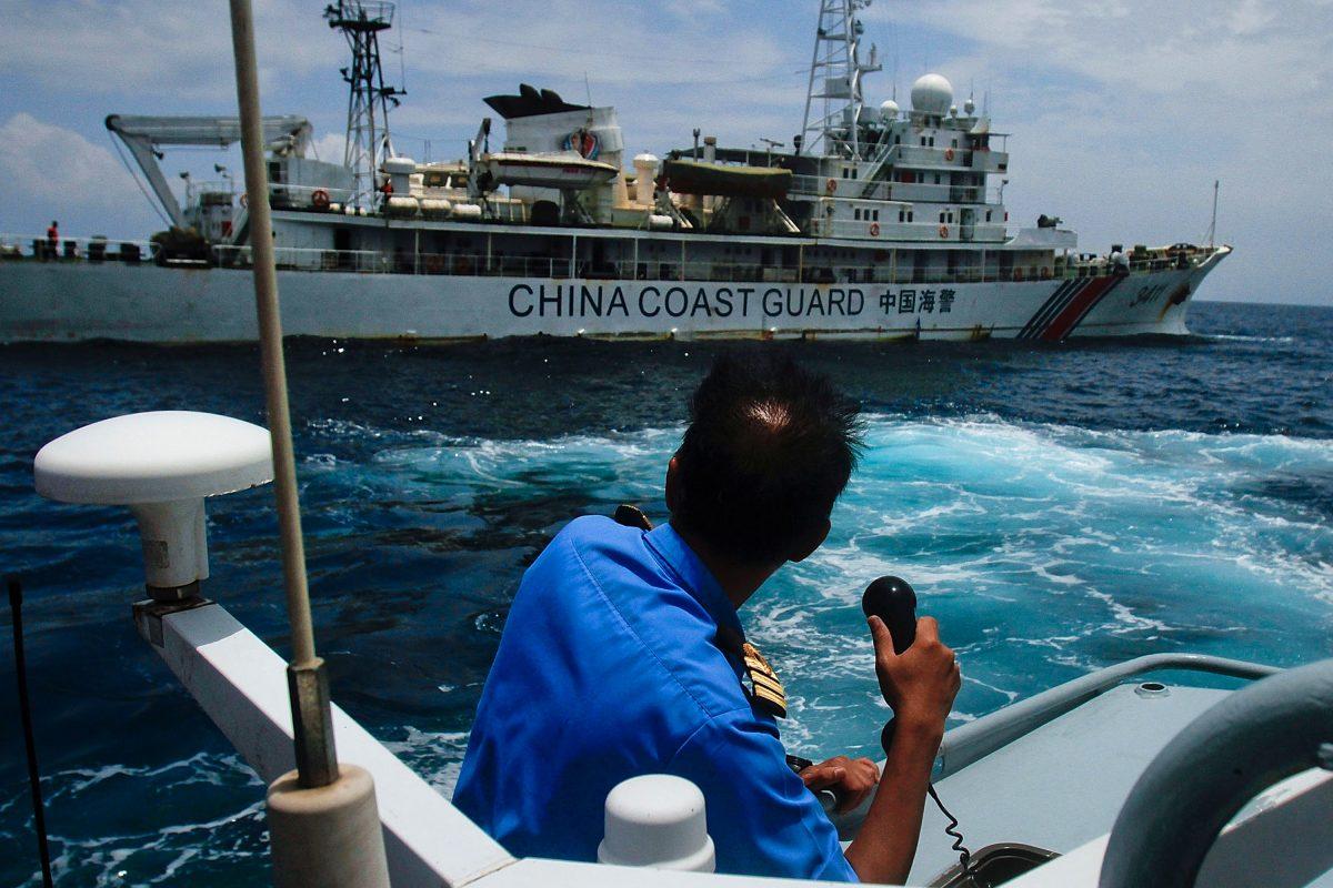 Chinese "little blue men" maritime militia in the South China Sea. A member of the Malaysian Navy at a communication exchange with a Chinese Coast Guard ship in the South China Sea, near Kuantan, Malaysia, on March 15, 2014. (Rahman Roslan/Getty Images)