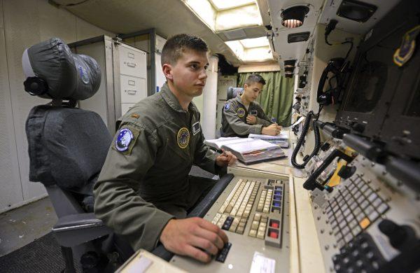 Second Lt. Oliver Parsons (L) and First Lt. Andy Parthum check systems in the underground control room where they work a 24-hour shift at an ICBM launch control facility near Minot, N.D., on June 24, 2014 The crew is responsible for controlling and launching the 10 nuclear-tipped Minuteman 3 missiles located in remote launch sites under their command. (Charlie Riedel/AP Photo)