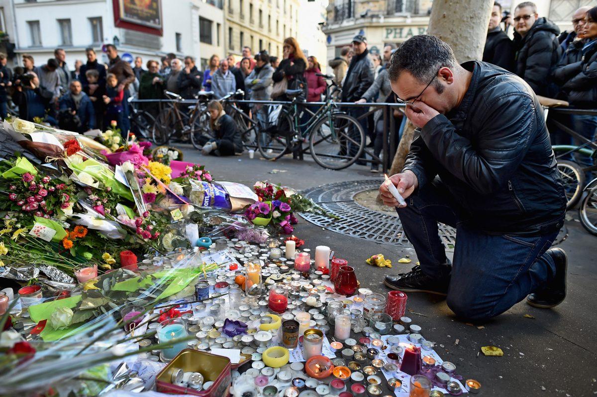 A man weeps as he lays flowers down at the La Belle Equipe restaurant on Rue de Charonne following the terrorist attacks in Paris, on Nov. 15, 2015. (Jeff J Mitchell/Getty Images)