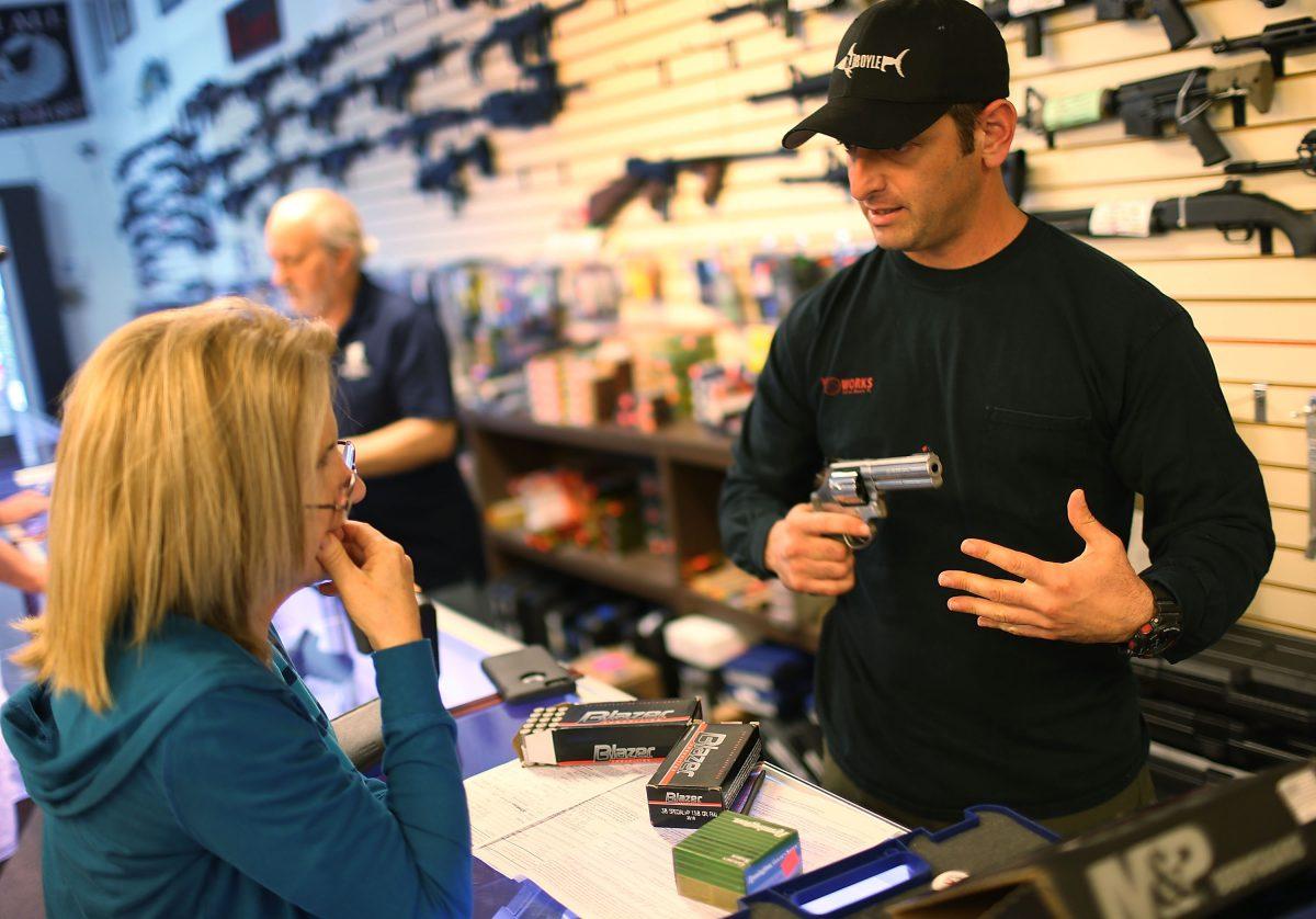 Brandon Wexler (R) shows Cindy Schneider the weapons that she was picking up at the end of the three day waiting period at the K&W Gunworks store on the day that U.S. President Barack Obama in Washington, D.C., announced his executive action on guns in Delray Beach, Fla., on Jan. 5, 2016. (Joe Raedle/Getty Images)