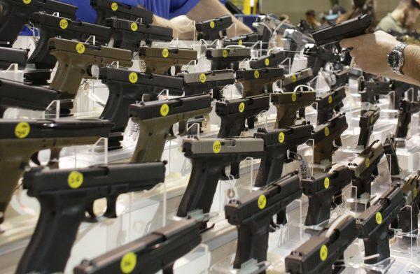 A customer looks at a pistol at a vendor's display at a gun show held by Florida Gun Shows in Miami on Jan. 9, 2016. (Lynne Sladky/AP Photo)