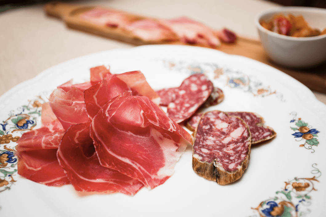 Delicate slices of culatello di Zibello, dubbed the “king of hams” (L), and salame Antico Spigaroli at Al Cavallino Bianco, Polesine Parmense. (Channaly Philipp/Epoch Times)