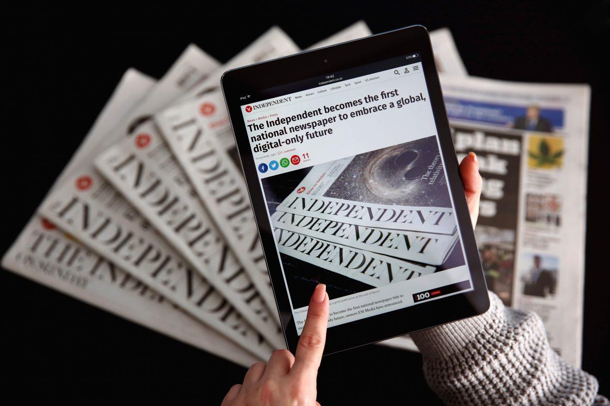 An iPad displays the Independent's online platform above a selection of the print versions of their titles on Feb. 12, 2016. (Dan Kitwood/Getty Images)