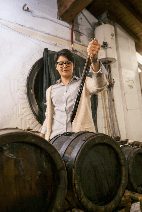 Sofia Malagoli draws a sample of traditional balsamic vinegar from one of the barrels housed in the attic of her farmhouse, Castelfranco Emilia. (Channaly Philipp/Epoch Times)