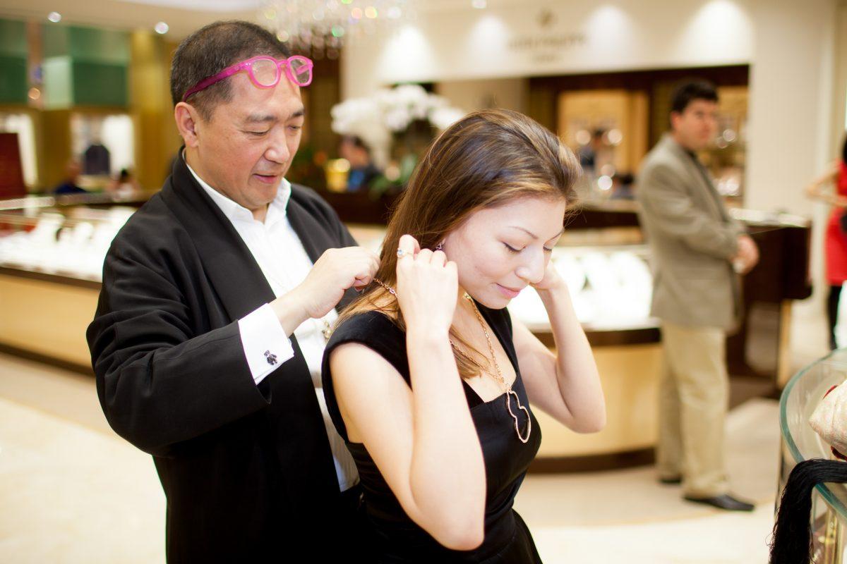 Qeelin co-founder Dennis Chan helps Katherine Park with the Wu Lu pendant during the unveiling of Qeelin Collections and Chinese New Year Festivities at CH Premier Jewelers in the Westfield Shopping Center in Santa Clara, Calif., on Feb. 20. (Christian Lambert for Epoch Times)