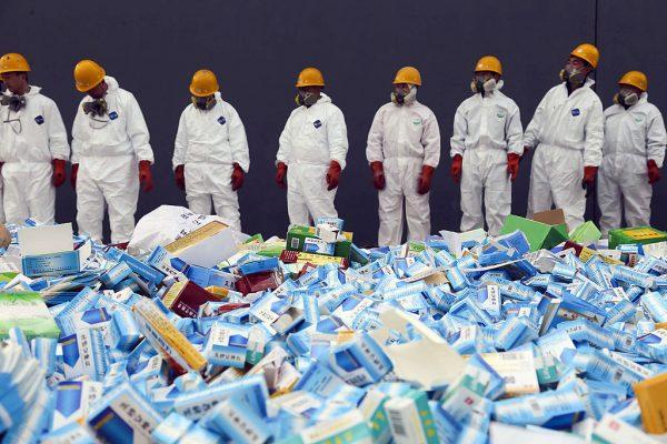 Health workers prepare to destroy fake medicines seized in Beijing on March 14, 2013. A man in Shandong survives after taking 200 fake sleeping pills. (STR/AFP/Getty Images)