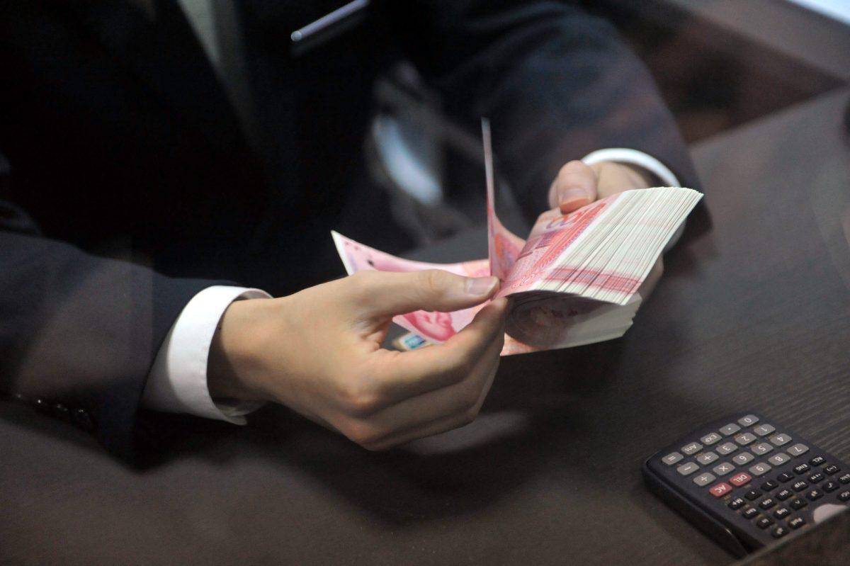 A bank employee counts 100-yuan banknotes at a bank in Hangzhou, east China's Zhejiang Province on Dec. 1, 2015. (STR/AFP/Getty Images)