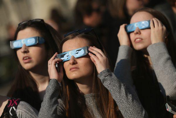 People use special glasses to look into the sky at a partial solar eclipse near the Brandenburg Gate in Berlin, Germany, on March 20, 2015. (Sean Gallup/Getty Images)
