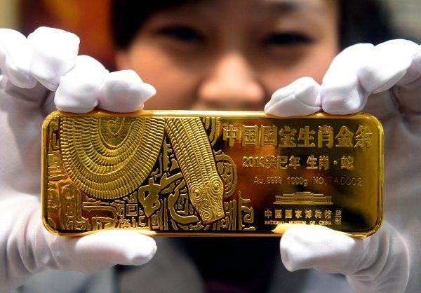 A woman holds a gold bar to mark the year of the snake in Beijing in 2012. (STR/AFP/Getty Images)