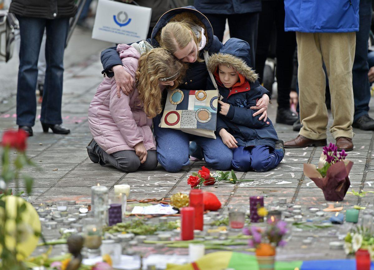 A woman holds her children as they mourn for the victims of the bombings at the Place de la Bourse in the center of Brussels, on Mar. 23, 2016. (Martin Meissner/AP Photo)