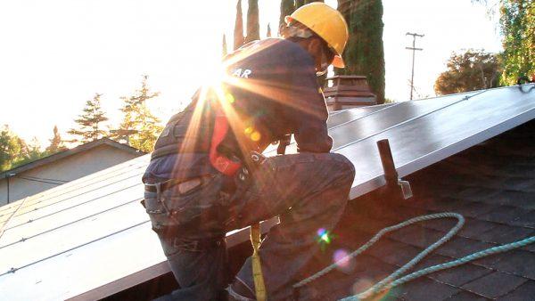 Solar panels being installed in "Catching the Sun." (7th Empire Media)