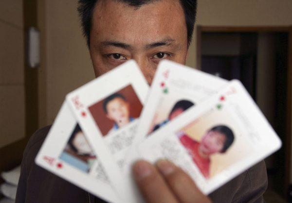 "Missing children playing cards" are displayed by Shen Hao, founder of the missing person wetsite XRQS.com, in Beijing, China, on March 31, 2007. (China Photos/Getty Images)